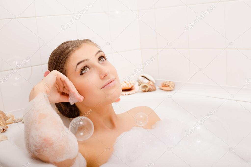 Young lovely woman in foam bath