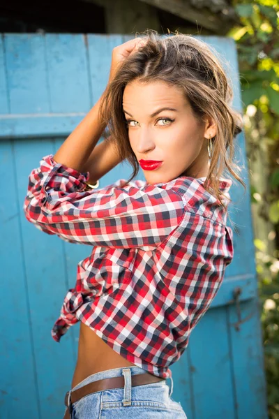 Jovem sedutora menina bonita em camisa e jeans — Fotografia de Stock