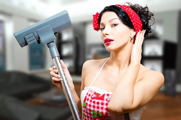 Pinup lady holding hoover in apartment — Stock Photo, Image