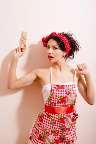 Mulher incrível em Alice vermelho polka dot band mordendo pincel — Fotografia de Stock