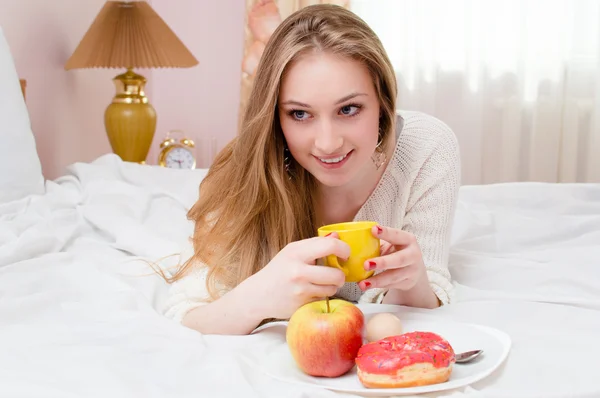 Mujer joven desayunando en la cama —  Fotos de Stock