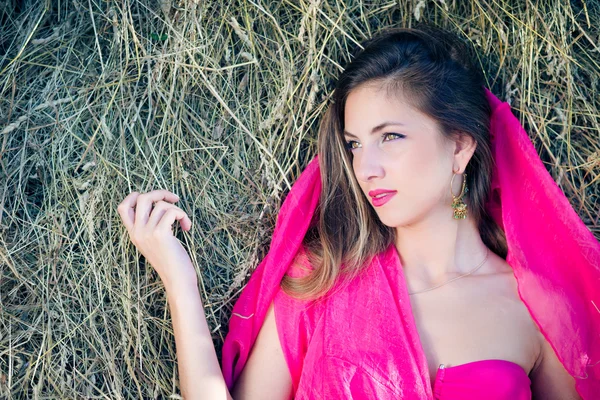 Meisje met roze doek over lange haren — Stockfoto