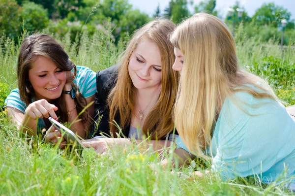 Drei Mädchen mit Tablet im Park — Stockfoto