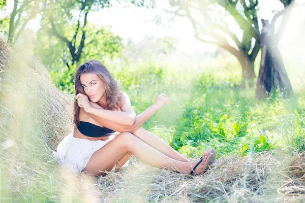brunette girl hugging herself on hay