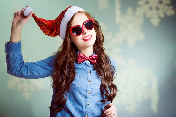 Girl in Christmas hat and heart-shaped glasses — Stock Photo, Image