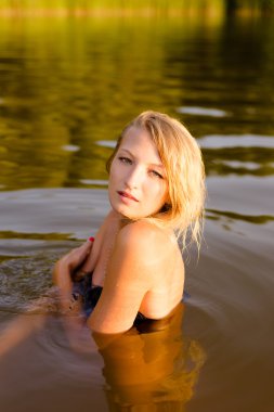 woman with naked shoulders bathing in lake
