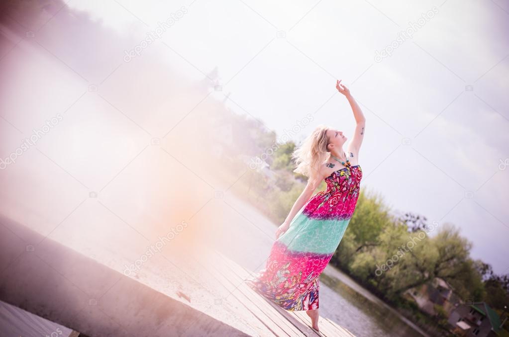 gracious young woman dancing by lake