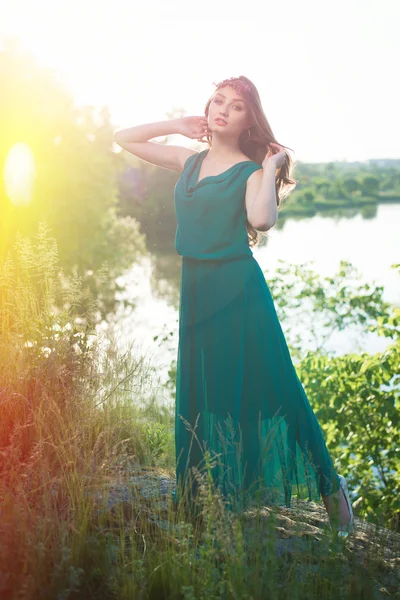 Lady in green dress posing by river — Stok fotoğraf