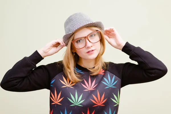 Girl in glasses touching her hat with hands — Stock Photo, Image