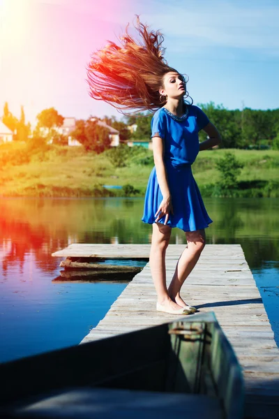Lady with flying hair standing on bridge Stock Photo
