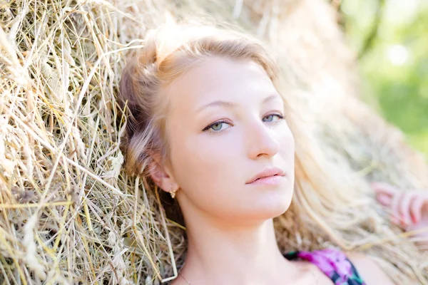 Блондинка лежит на стоге сена — стоковое фото
