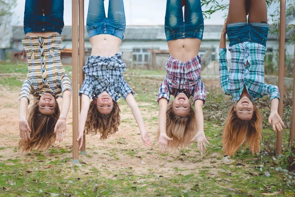 Girls hanging upside down having fun — Stockfoto