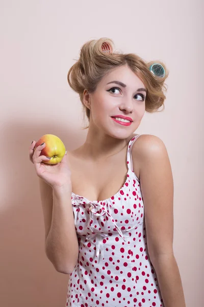 Pin up ragazza in bigodini con mela — Foto Stock