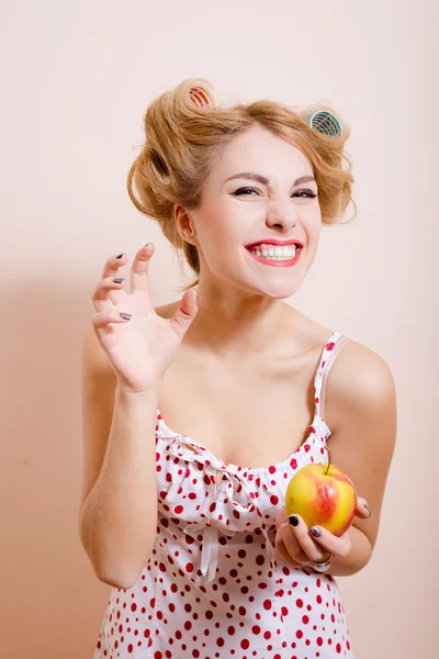 Dama en lencería y rulos sosteniendo manzana —  Fotos de Stock