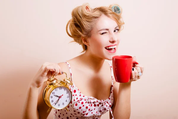 Smiling housewife with alarm-clock and cup — Stok fotoğraf