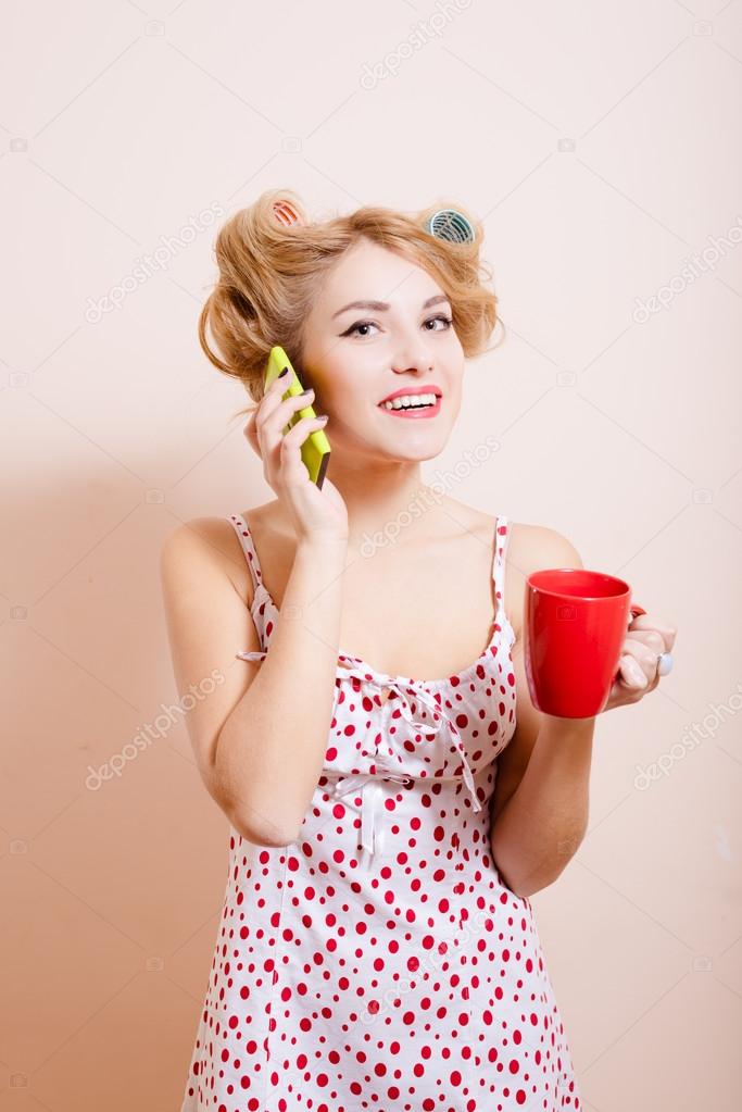 Housewife with red cup talking on mobile