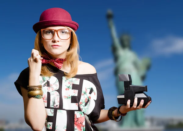 Girl with polaroid on New York background — Stockfoto