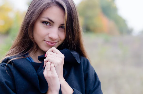 Charming girl in coat gently smiling — Stockfoto