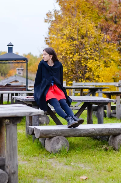 Frau sitzt auf Holztisch — Stockfoto