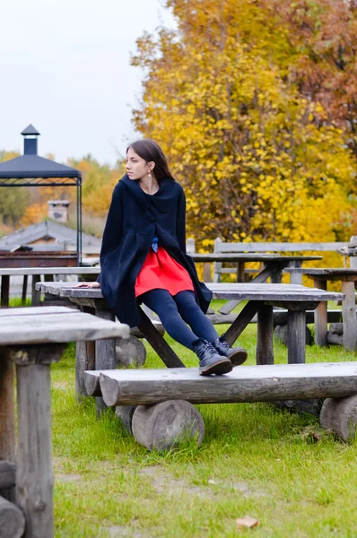 Woman sitting on wooden table — Stock fotografie