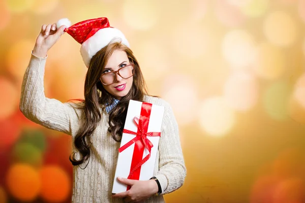 Женщина в шляпе Санта-Клауса, держащая в руках коробку с потрохами — стоковое фото
