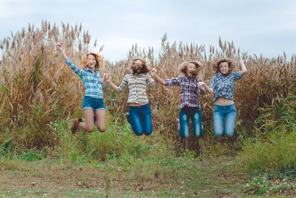 Girls jumping and holding hands — Stock Photo, Image