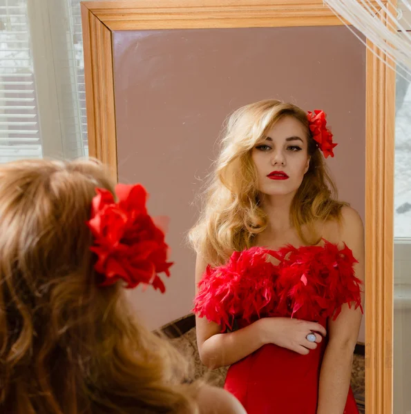 Signora in abito rosso guardando allo specchio — Foto Stock