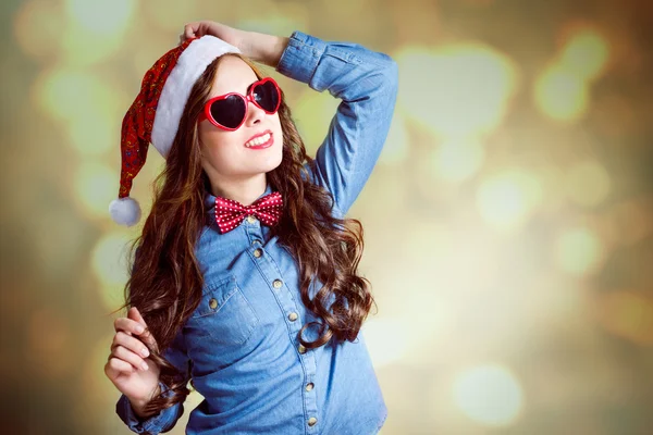 Flicka i hjärtformade solglasögon och santa hatt — Stockfoto