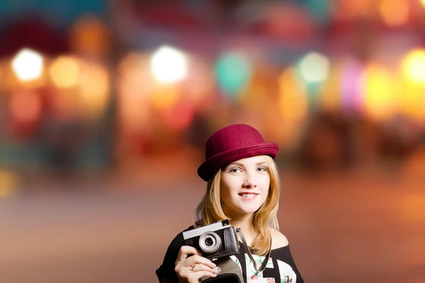 Csinos lány a csípő szemüveg és a gazdaság vintage kamera kalap — Stock Fotó