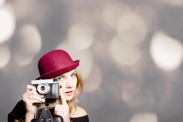 Pretty girl in hipster glasses and hat holding vintage camera — Stock Photo, Image