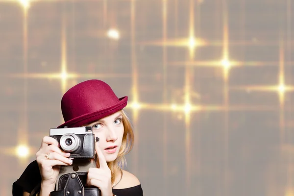 Pretty girl in hipster glasses and hat holding vintage camera — Stock Photo, Image