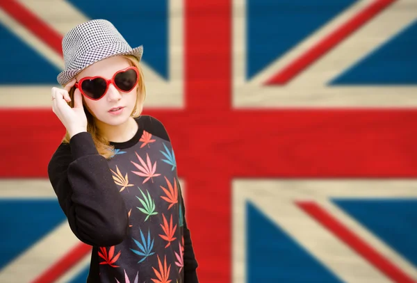 Pretty young woman in sunglasses on english union jack background — 图库照片