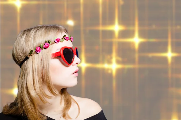 Beautiful girl in heart shaped sunglasses on bokeh background — Stockfoto