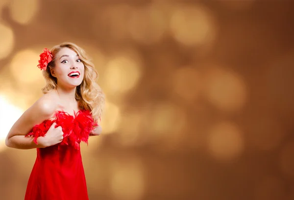 Pretty girl in red dress excited on bokeh lights background — ストック写真