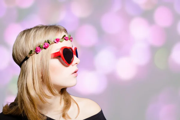 Beautiful girl in heart shaped sunglasses on bokeh background — Stok fotoğraf