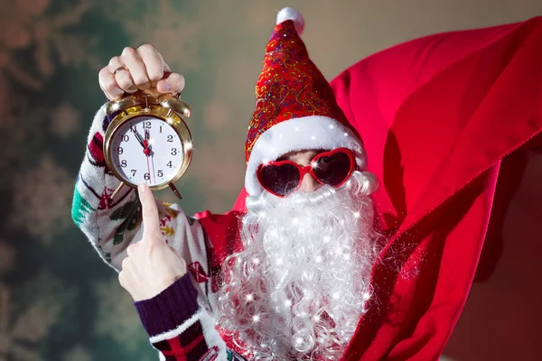 Funky Santa Claus con reloj despertador con gafas de sol en forma de corazón —  Fotos de Stock