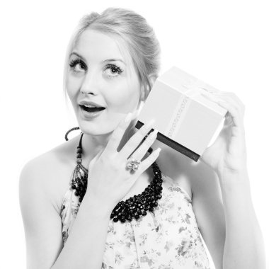 beautiful blond young woman having fun listening to gift box