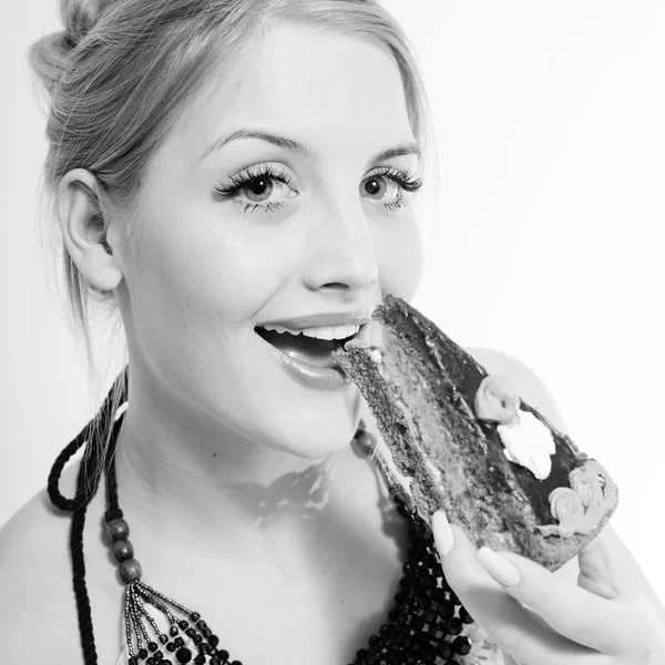 Schöne blonde junge Frau essen Schokoladenkuchen glücklich lächelnd — Stockfoto