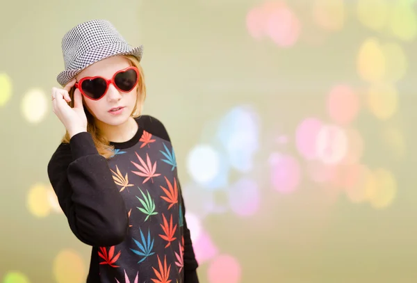 Pretty girl in fancy sunglasses on colorful bokeh blurred background — Stok fotoğraf