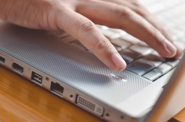 Fechar os dedos tocando teclado na mesa de madeira de fundo superior — Fotografia de Stock