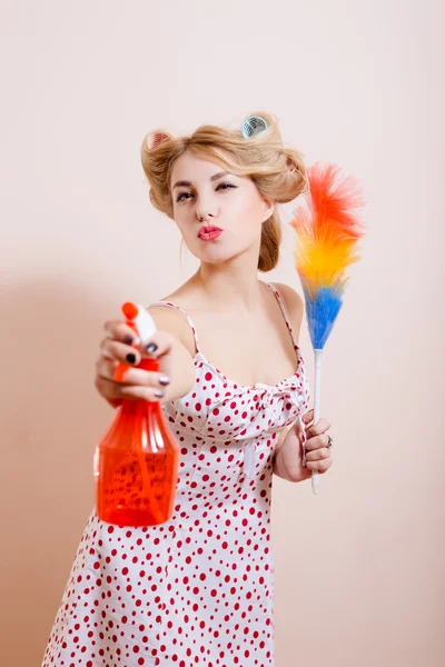 Sexy girl in curles pointing by spray bottle at camera — Stock Photo, Image