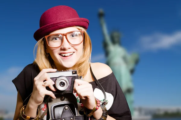 Menina bonita em óculos com câmera no fundo de Nova York . — Fotografia de Stock
