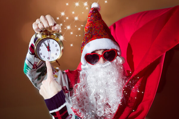Man in Santa Claus costume with  clock