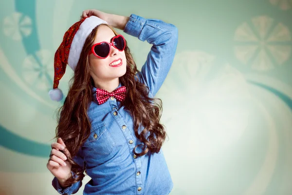 Funny hipster girl in heartshape sunglasses wearing xmas santa hat — Stock Photo, Image