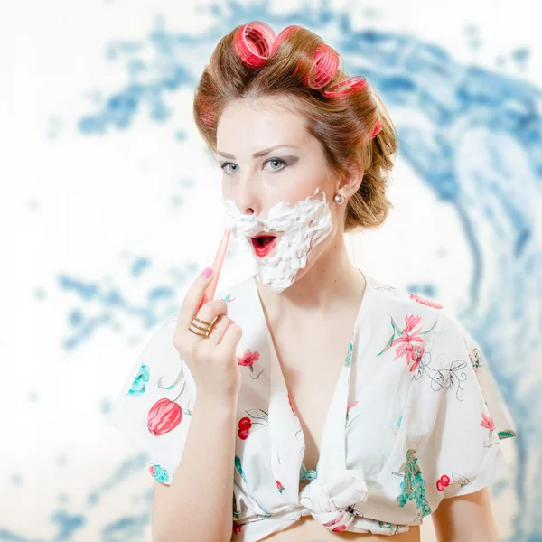 Beautiful young pinup woman shaving face with foam and razor — 图库照片