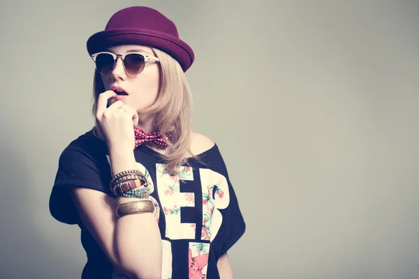 Stylish hipster girl posing in studio wearing hat and sunglasses and vinta — Zdjęcie stockowe