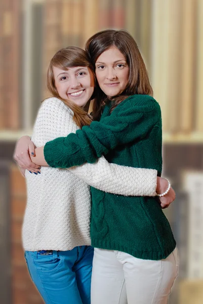 两个美丽的快乐十几岁的女孩在自制的毛衣拥抱 — 图库照片