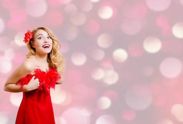 Pretty girl in red dress excited on bokeh lights background — Stockfoto