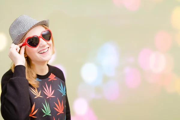 Pretty girl in fancy sunglasses on colorful bokeh blurred background — Stok fotoğraf
