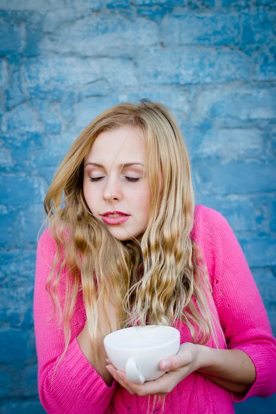 İçecek fincan tutan çekici genç kadın — Stok fotoğraf